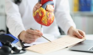 plastic-heart-model-doctor-examine-electrogram-result-professional-diagnostic_151013-36500