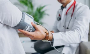 young-male-psysician-with-patient-measuring-blood-pressure_1303-17877